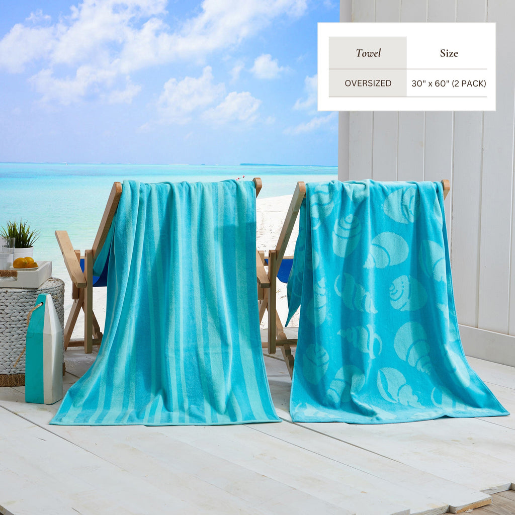 Maui Cotton Velour Beach Towel in vibrant green designs displayed on a chair by the beach.