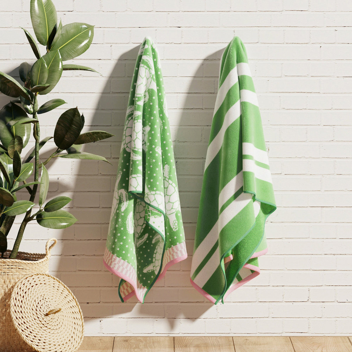 Maui Cotton Velour Beach Towel in vibrant green designs displayed on a chair by the beach.