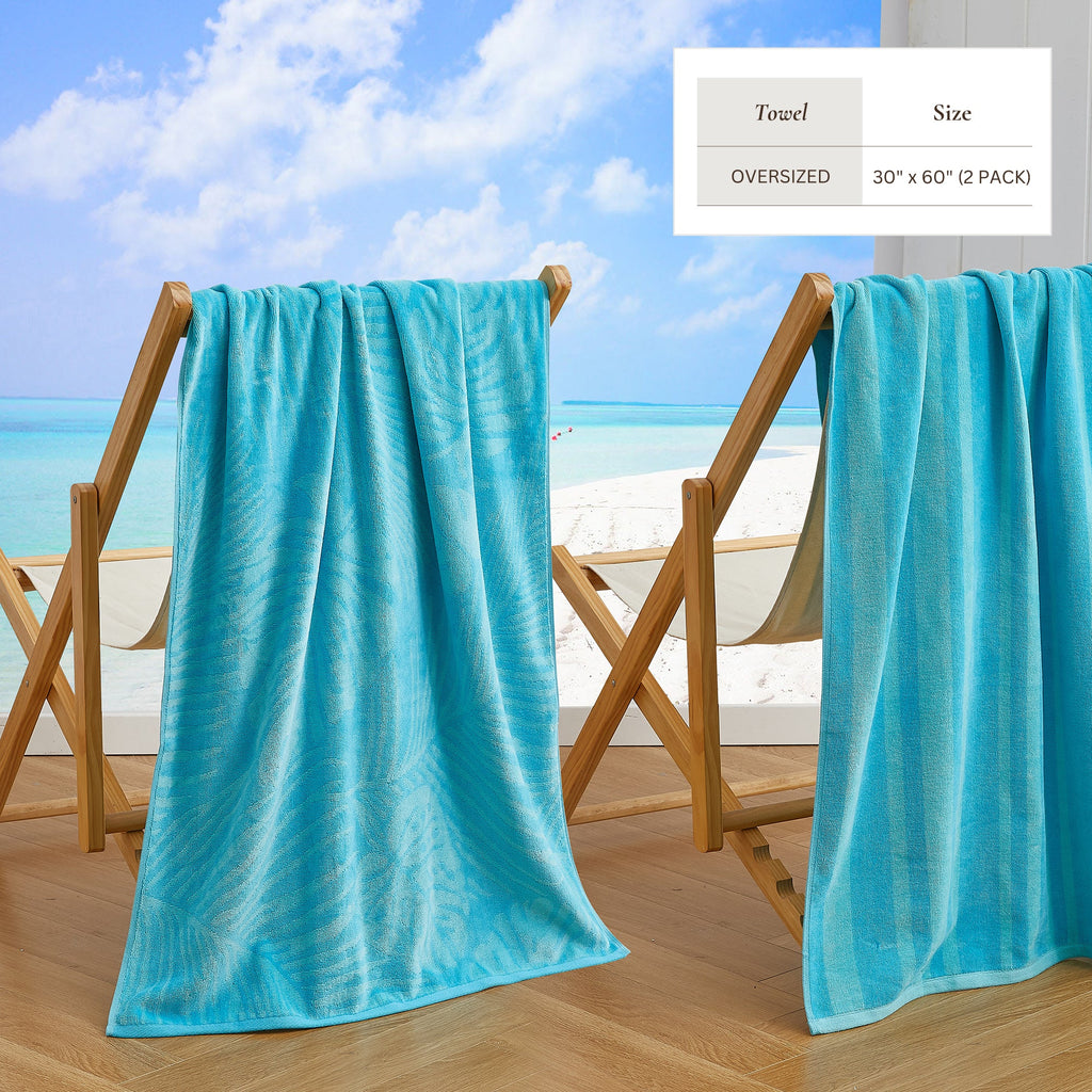 Maui Cotton Velour Beach Towel in vibrant green designs displayed on a chair by the beach.