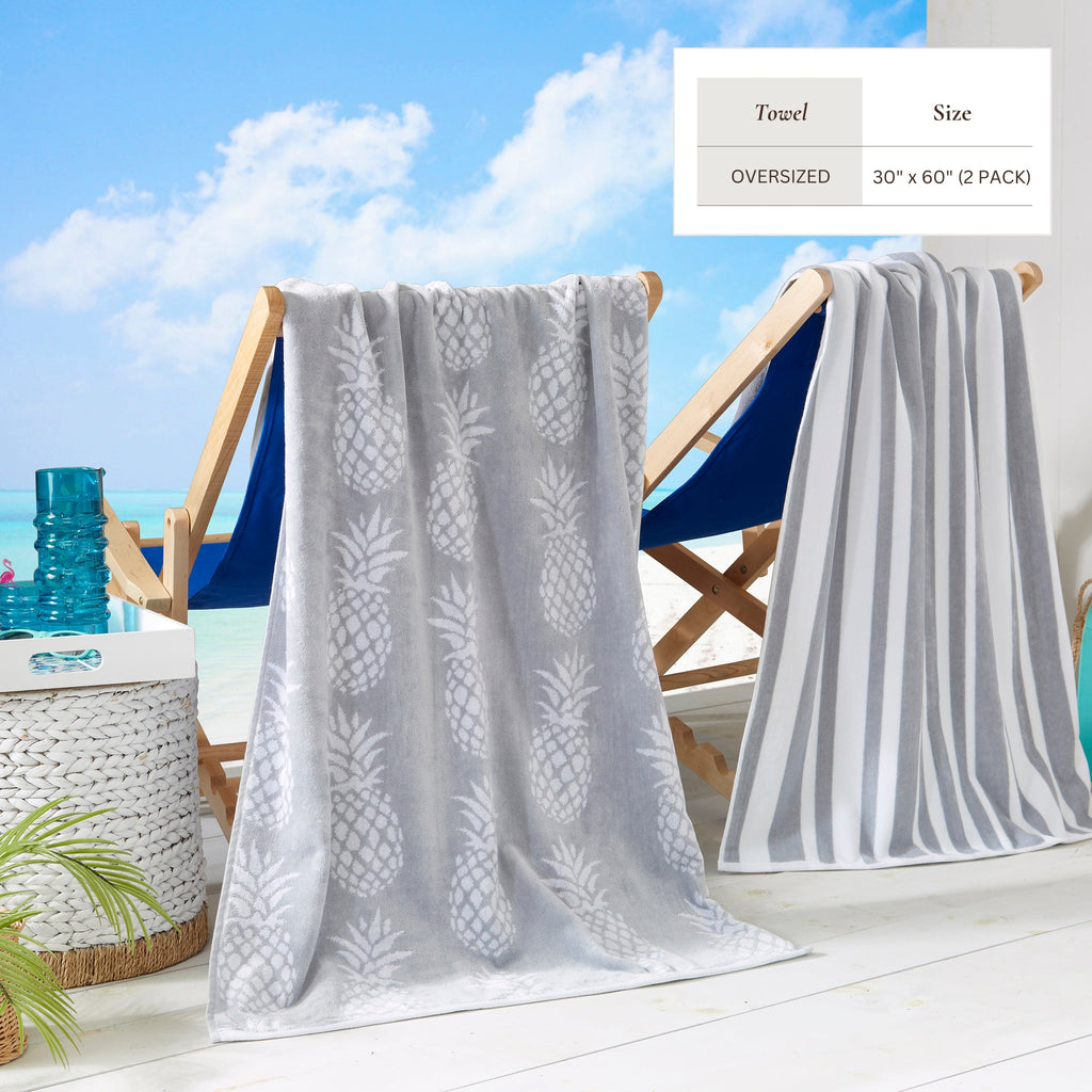 Maui Cotton Velour Beach Towel in vibrant green designs displayed on a chair by the beach.
