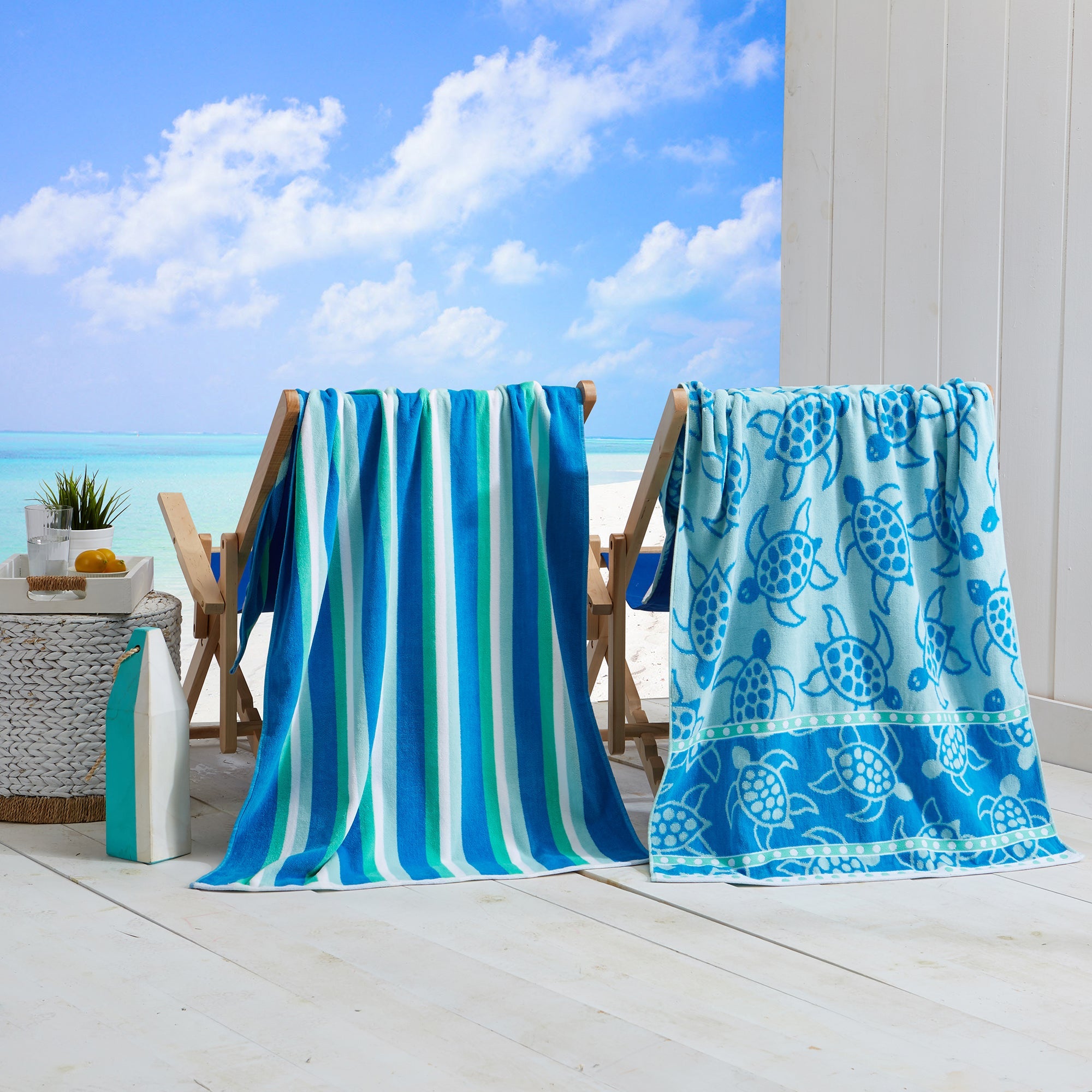Maui Cotton Velour Beach Towel in vibrant green designs displayed on a chair by the beach.