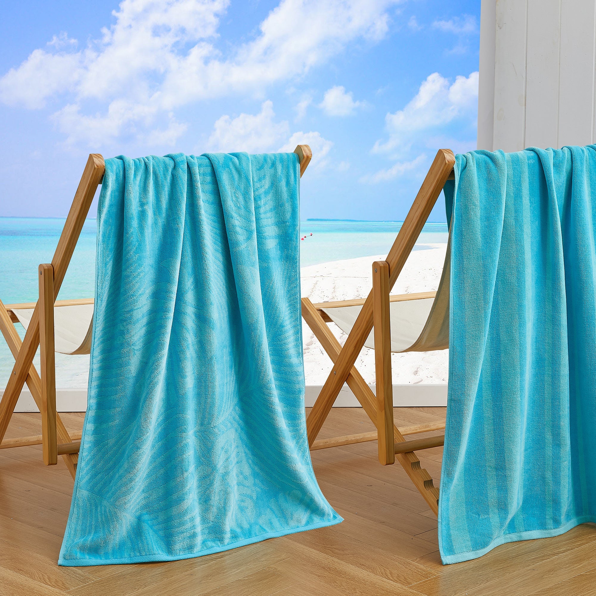 Maui Cotton Velour Beach Towel in vibrant green designs displayed on a chair by the beach.