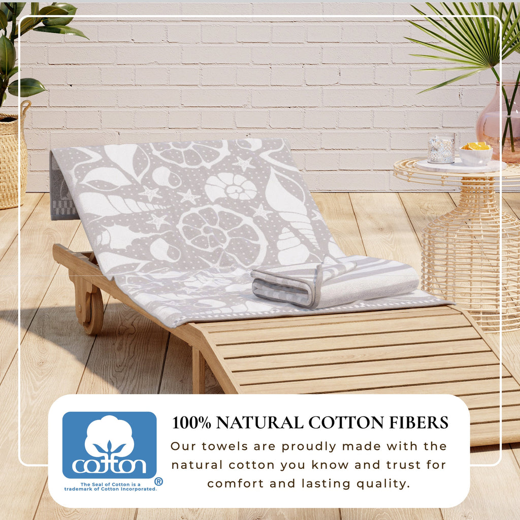 Maui Cotton Velour Beach Towel in vibrant green designs displayed on a chair by the beach.